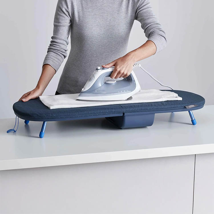 Foldable ironing board with iron storage